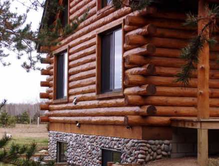 A log cabin in Minnesota with rustic hand peeled half log with butt and pass corners